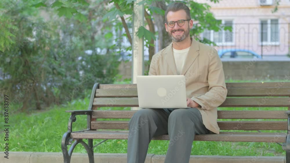 Young Man with Laptop Smiling at Camera while Sitting Outdoor Young Man with Laptop Smiling at Camera while Sitting Outdoor