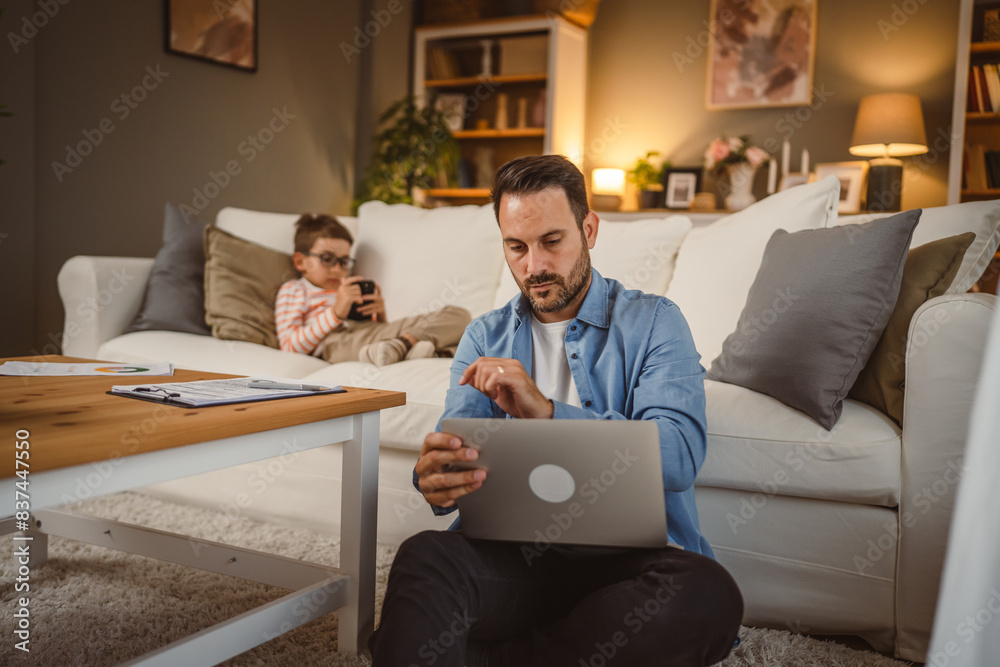 Father work from home use laptop with son at background Father work from home use laptop with son at background