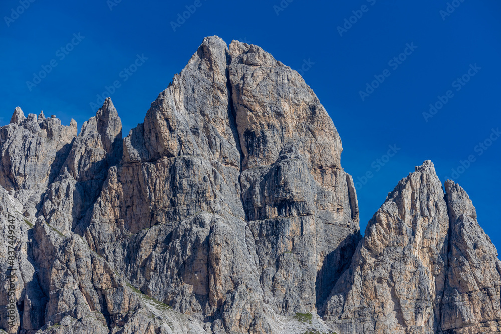 Dolomiti Alps beautiful mountain landscape. Rocky tower alpine summits in the Dolomites. Summer mountain scenic view on the hiking trekking path in the green mountain valley and blue sky with clouds Dolomiti Alps beautiful mountain landscape. Rocky tower alpine summits in the Dolomites. Summer mountain scenic view on the hiking trekking path in the green mountain valley and blue sky with clouds
