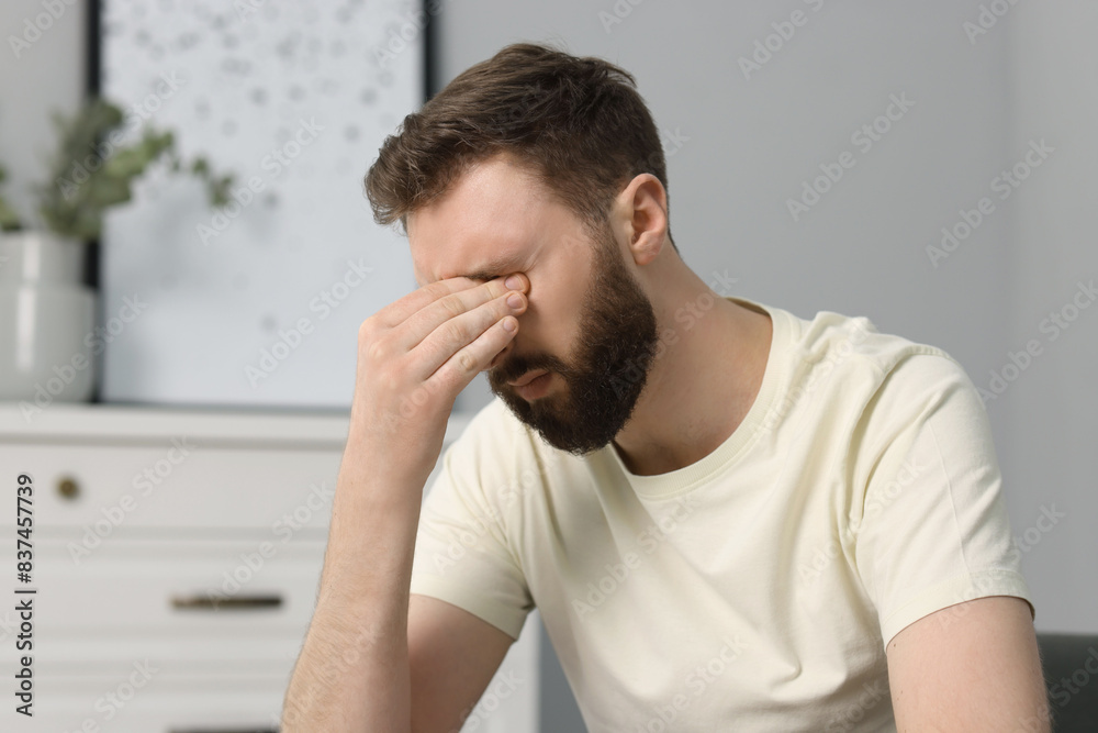 Overwhelmed man suffering from headache at home Overwhelmed man suffering from headache at home