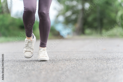 ダイエット・カロリー消費のため公園でウォーキング・運動をするスポーツウェアのアジア人女性の足元
 photo