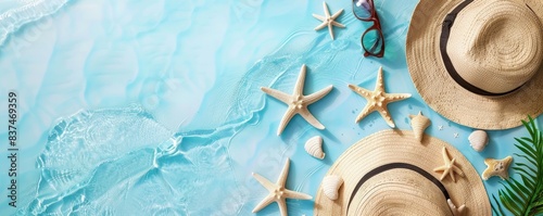 Top view of summer beach accessories including straw hats, sunglasses, starfish, and shells on a blue background. Perfect for vacation themes. photo
