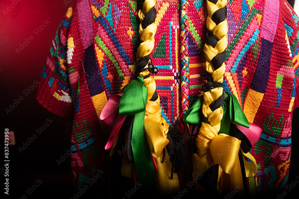 A person wearing a colorful shirt with a long braid on the back