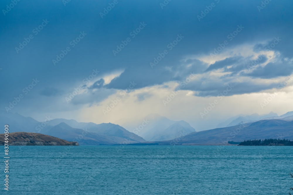 View of storm clouds over mountain from Lake Tekapo, Canterbury, New Zealand. View of storm clouds over mountain from Lake Tekapo, Canterbury, New Zealand.