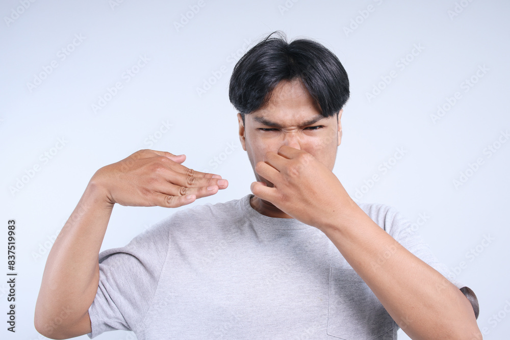 Potrait Of Young Asian Man Showing Unpleasant Smell Isolated On White Background Potrait Of Young Asian Man Showing Unpleasant Smell Isolated On White Background
