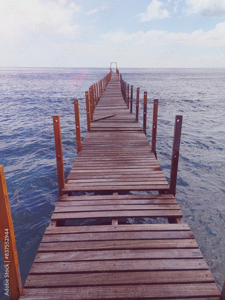 Wooden bridge on the tropical beach and blue sky summer background Wooden bridge on the tropical beach and blue sky summer background