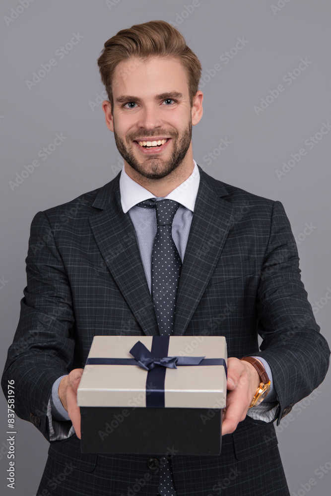 Business reward. Business man with corporate gift box isolated on grey. Corporate present. Mens day. Successful boss share gift box. Businessman prepare for romance date. Selective focus Business reward. Business man with corporate gift box isolated on grey. Corporate present. Mens day. Successful boss share gift box. Businessman prepare for romance date. Selective focus