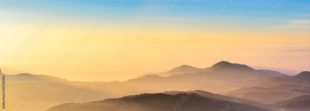 Mountain range panorama in sunrise sky, mountain ridge in sunlight.