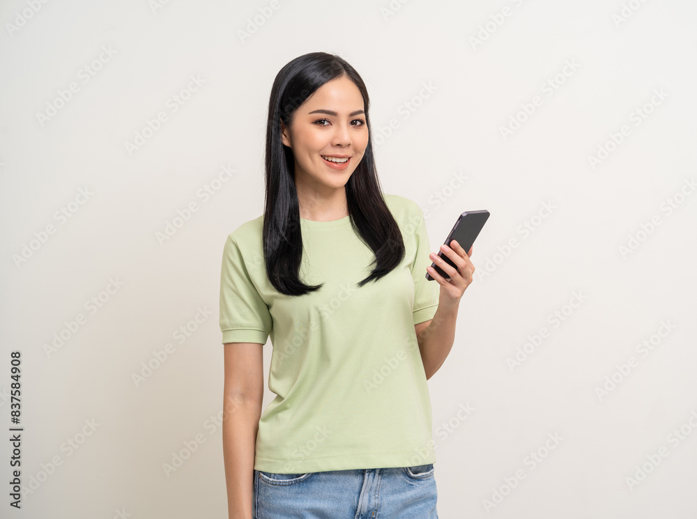 Pretty young asian woman using cellphone standing on isolated white background. Happy Excited Beautiful young asian shopping online payment with mobile phone. Playing game on smartphone Pretty young asian woman using cellphone standing on isolated white background. Happy Excited Beautiful young asian shopping online payment with mobile phone. Playing game on smartphone