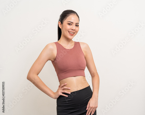 Young beautiful smiling asian woman with sportswear on isolated white background. Portrait happy healthy slim fit and firm latin attractive sporty woman standing pose exercise workout in studio. © Chanakon