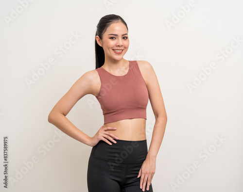Young beautiful smiling asian woman with sportswear on isolated white background. Portrait happy healthy slim fit and firm latin attractive sporty woman standing pose exercise workout in studio. © Chanakon