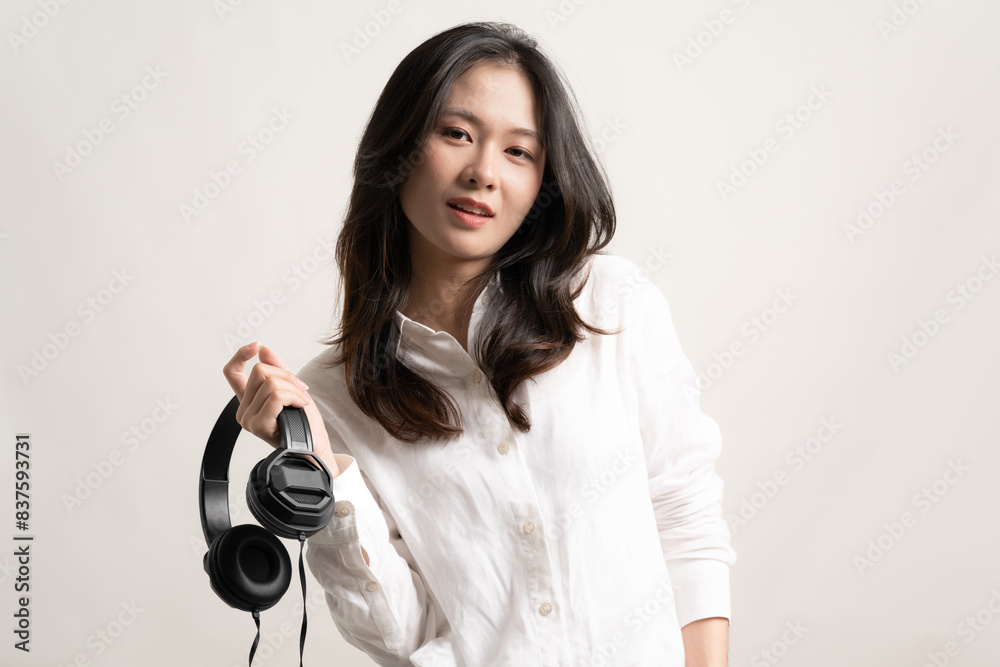 Portrait young happy asian woman wear white shirt and headphones listen to music with smile have fun isolated on white background.Beautiful girl smiling and funny listen music at home.Life style Portrait young happy asian woman wear white shirt and headphones listen to music with smile have fun isolated on white background.Beautiful girl smiling and funny listen music at home.Life style