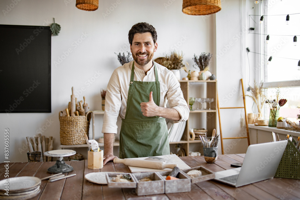 © sofiko14 - Concept of small business and trade in handmade products. Happy Caucasian bearded male potter making dishes from clay for online sales. © sofiko14 - Concept of small business and trade in handmade products. Happy Caucasian bearded male potter making dishes from clay for online sales.