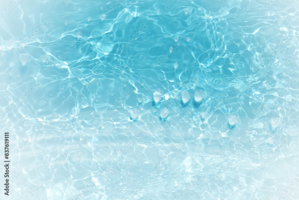 Blue water with ripples on the surface. Defocus blurred transparent blue colored clear calm water surface texture with splashes and bubbles. Water waves with shining pattern texture background. Blue water with ripples on the surface. Defocus blurred transparent blue colored clear calm water surface texture with splashes and bubbles. Water waves with shining pattern texture background.