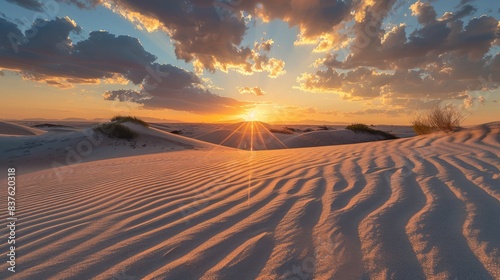 Scenic sunrise casting golden light and long shadows over the tranquil sand dunes 