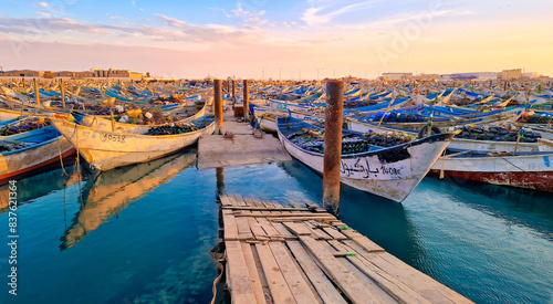 Colorful fishing boats docked at Nouadhibou Harbor at sunset photo