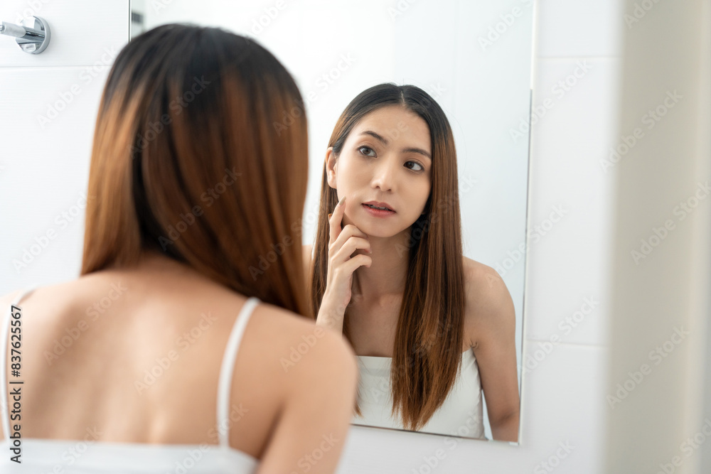 Self confident women look in the mirror brush up their hair and admire their body. Young asian beautiful woman who takes care of herself well. Check facial skin Self confident women look in the mirror brush up their hair and admire their body. Young asian beautiful woman who takes care of herself well. Check facial skin