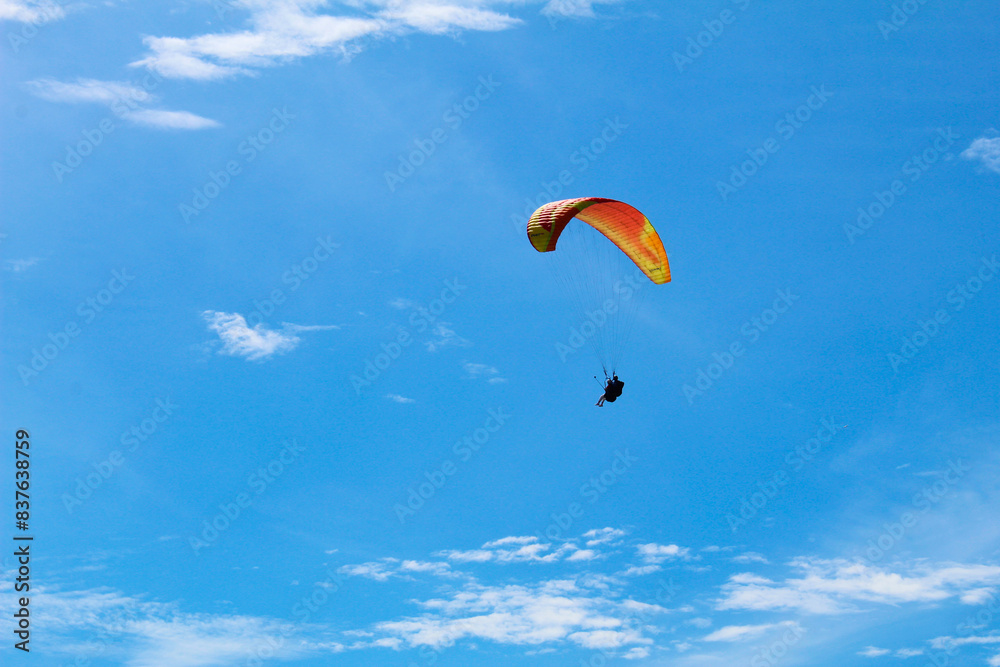 Photograph of a paraglider soaring against a clear blue sky. Captures the thrill and freedom of paragliding Photograph of a paraglider soaring against a clear blue sky. Captures the thrill and freedom of paragliding