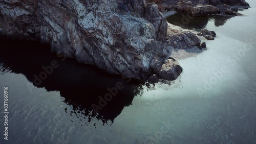 Captivating aerial perspective of a rocky cliff formation in the beautiful waters of Portugal. photo