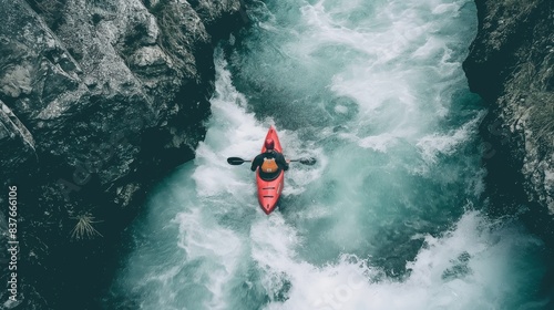 An overhead shot captures a kayaker braving the turbulent white waters of a narrow river passage photo