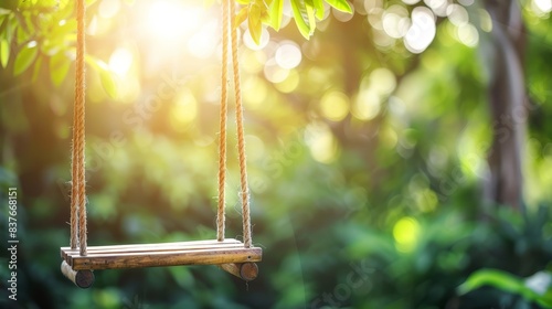  A wooden swing suspended from a tree in a forest Sunlight filters through the leafy canopy in the foreground, while the sun shines behind, bathed in golden light