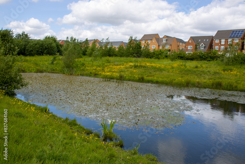 Fotografija Aerial drone photo over looking the area of Leeds known as Middleton in West Yorkshire, showing a large pond next to the newly built housing estate taken on a sunny part cloudy day
