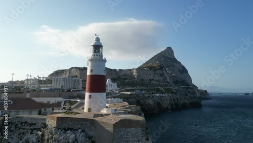 A picturesque 4K drone shot rising up from the sea and revealing a lighthouse and the rock of Gibraltar at it's southernest point.