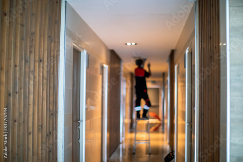 Blurry picture of Technician is replacing or repair a smoke detector in an office building or condominium.  Technician is checking a fire alarm system at smoke detector. © Koonsiri