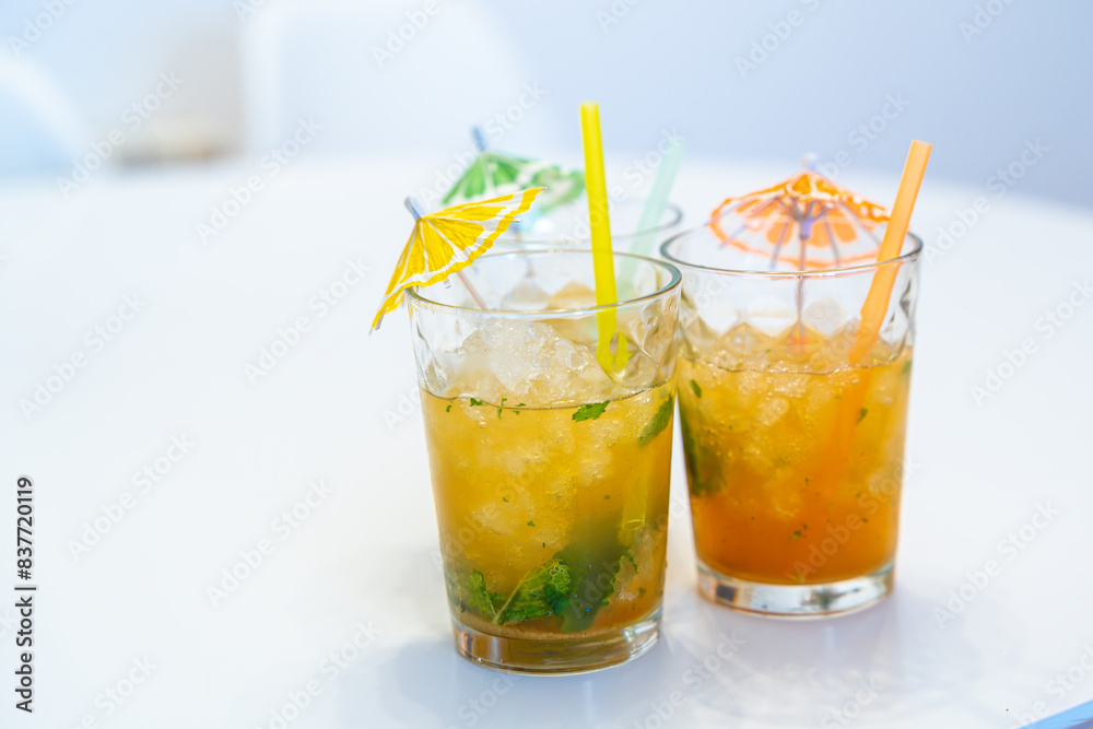 Mojito cocktails with umbrella and straw on a table Mojito cocktails with umbrella and straw on a table