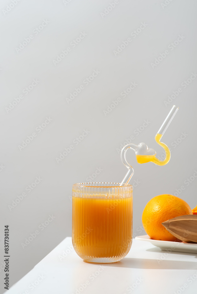 A glass of refreshing orange juice placed beside a plate of fresh oranges A glass of refreshing orange juice placed beside a plate of fresh oranges