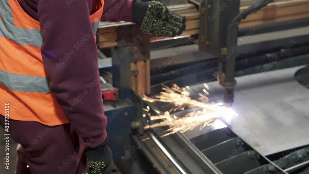 Plasma cutting of metal on a CNC machine. Industrial cutting of metal with a plasma laser at a metallurgical plant. Sparks fly from melting metal. Making metal parts using a computer program.