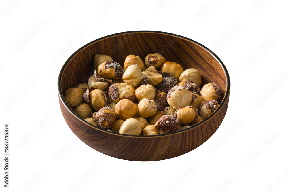 Obraz premium Roasted salted hazelnuts in wooden bowl on isolated white background