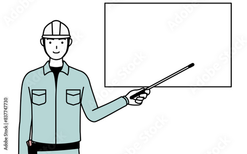 ホワイトボードを指示棒で指すヘルメットと作業着姿の男性