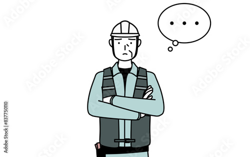 腕を組んで考えるヘルメットと作業着姿のシニア男性技師