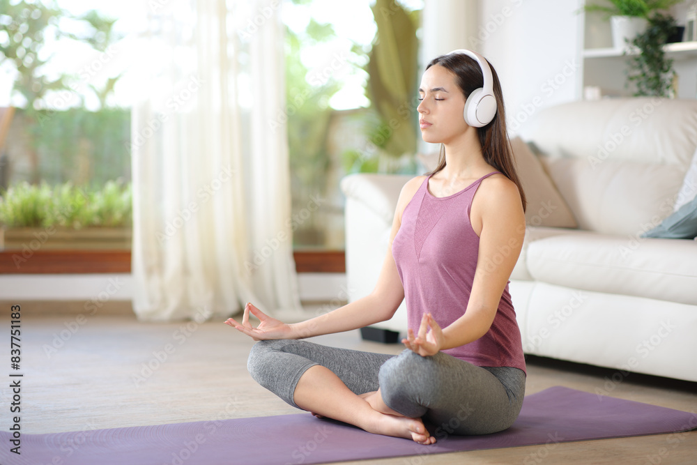 Yogi doing guided yoga exercise wearing headphone Yogi doing guided yoga exercise wearing headphone