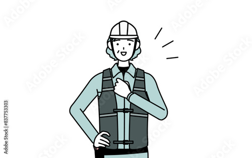 胸を叩くヘルメットと作業着姿のシニア女性技師