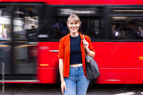 Woman with bag standing in front of moving bus at street