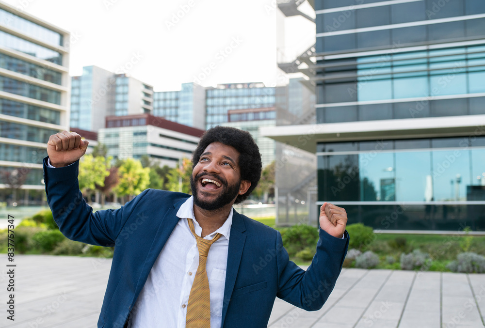 Happy young businessman cheering in office park Happy young businessman cheering in office park
