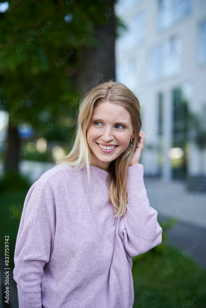 Smiling blond woman with hand in hair Smiling blond woman with hand in hair