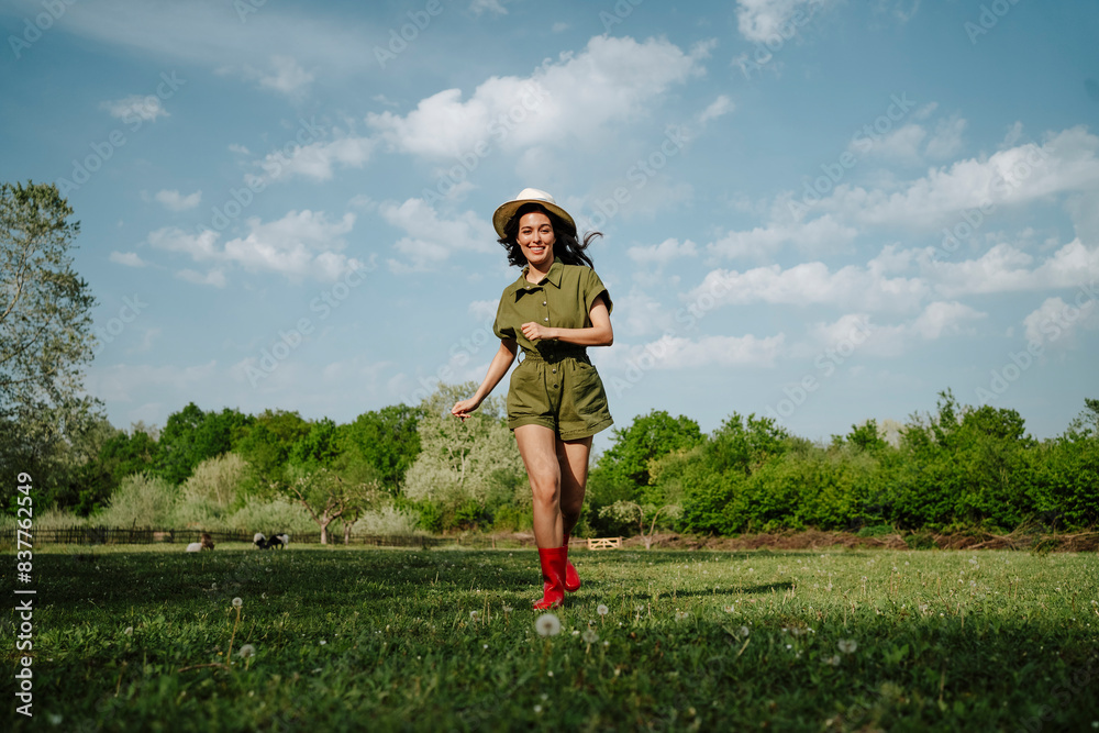 Happy woman running on field under cloudy sky Happy woman running on field under cloudy sky
