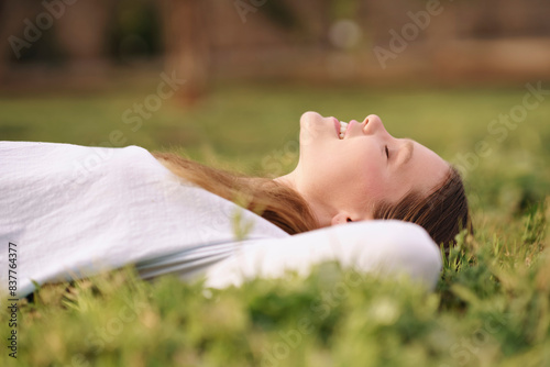 Smiling woman lying on back and relaxing at field photo