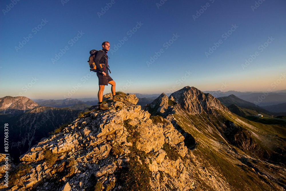 Man standing on Steinfeldspitze rock at sunrise in Altenmarkt, Zauchensee, Salzburg, Austria Man standing on Steinfeldspitze rock at sunrise in Altenmarkt, Zauchensee, Salzburg, Austria