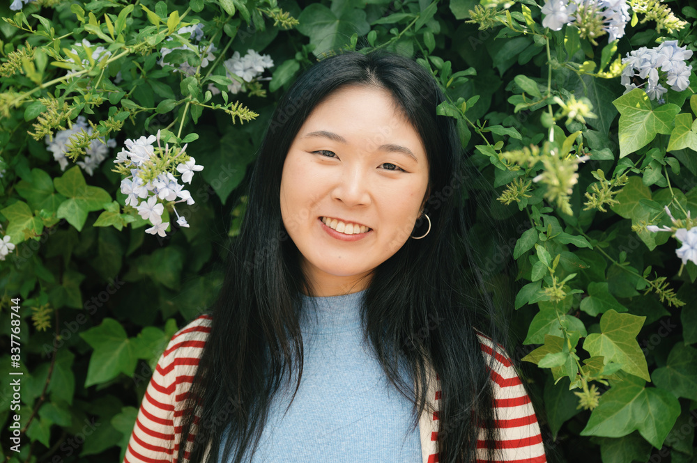 Beautiful woman standing near flowers at park