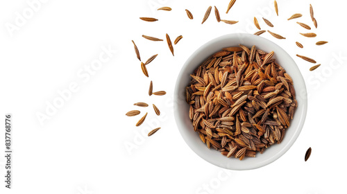 A white bowl filled with cumin seeds, with a few scattered around the bowl on a white background photo