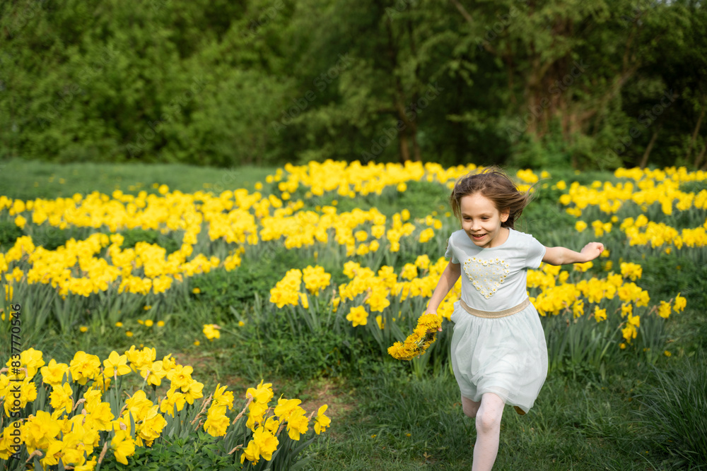 Happy girl running through daffodil field