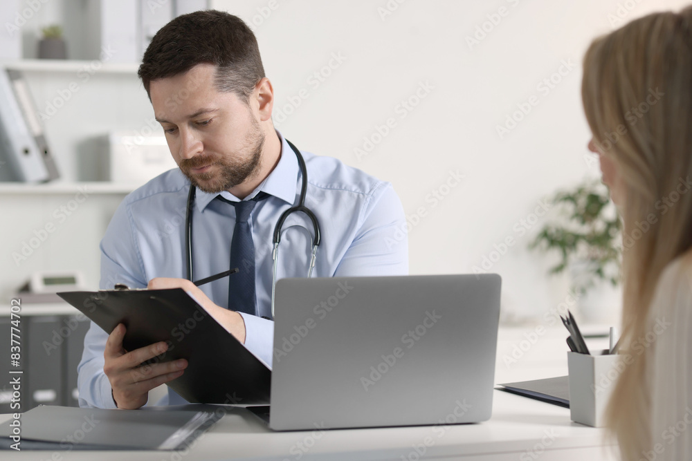 Professional doctor working with patient at white table in hospital Professional doctor working with patient at white table in hospital