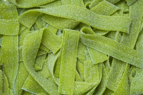 Green sour gummy jelly candy strips in sour apple flavor