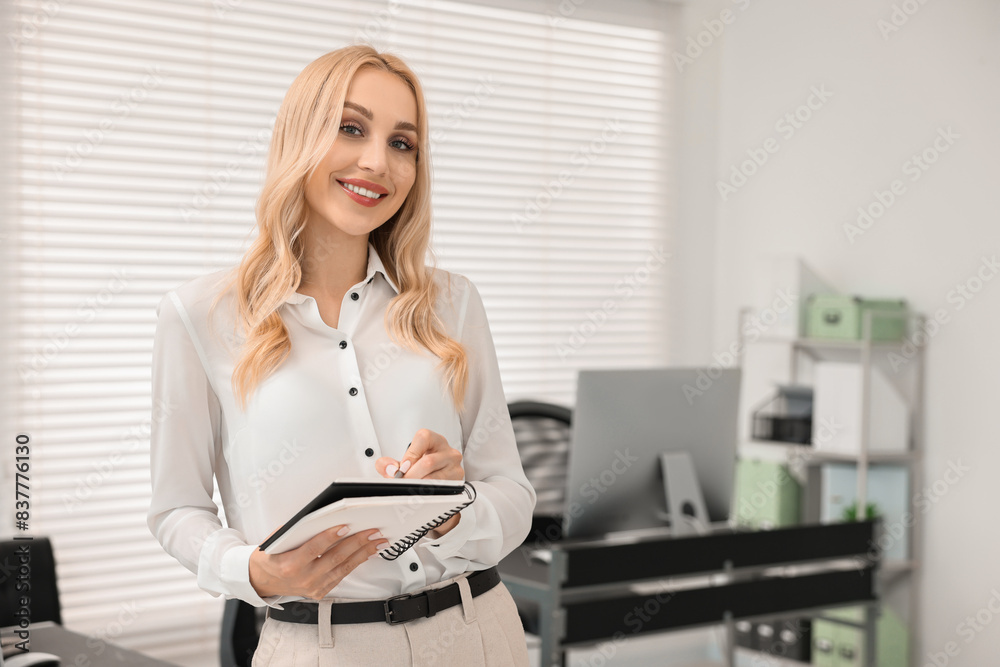 Happy secretary with notebook in office, space for text Happy secretary with notebook in office, space for text