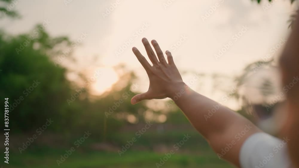The young man raised his hand and reached out towards the extremely beautiful sun. It's like reaching out to shake The young man raised his hand and reached out towards the extremely beautiful sun. It's like reaching out to shake