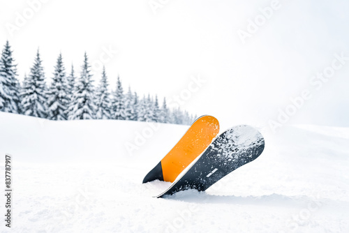 Snowboard stuck in the snow photo